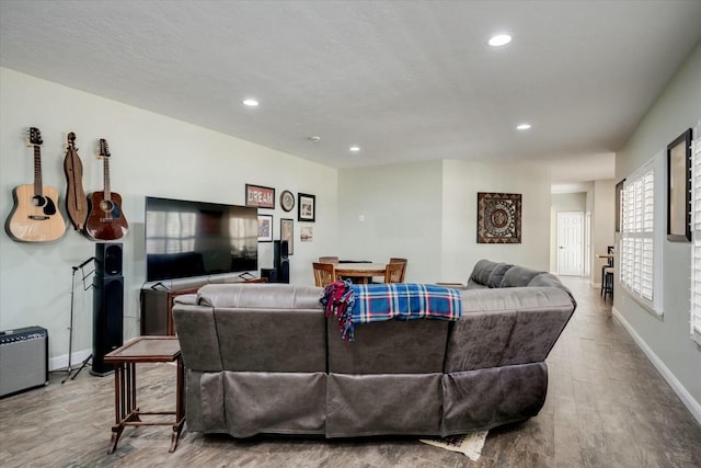 living area featuring recessed lighting, baseboards, and wood finished floors