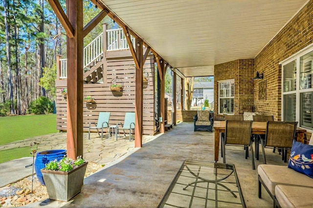 view of patio with outdoor dining space and stairs