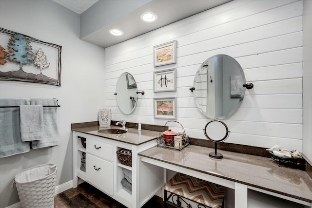 bathroom with vanity, recessed lighting, wood finished floors, and baseboards