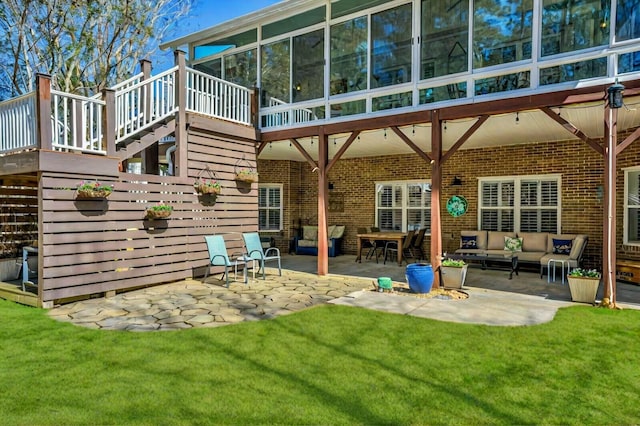 rear view of property featuring an outdoor living space, a yard, a patio, and brick siding