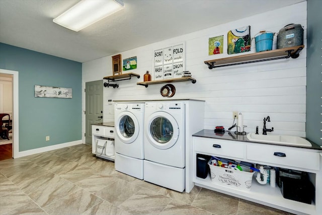 laundry room featuring laundry area, separate washer and dryer, baseboards, and a sink