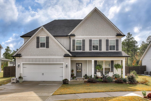 craftsman inspired home with a garage, a front yard, central AC unit, and a porch