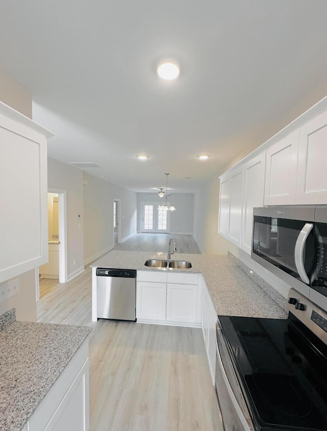 kitchen with sink, kitchen peninsula, ceiling fan, white cabinetry, and stainless steel appliances