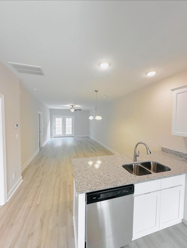 kitchen with white cabinets, stainless steel dishwasher, light stone countertops, and sink