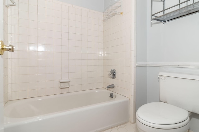 bathroom featuring tiled shower / bath combo, tile patterned floors, and toilet