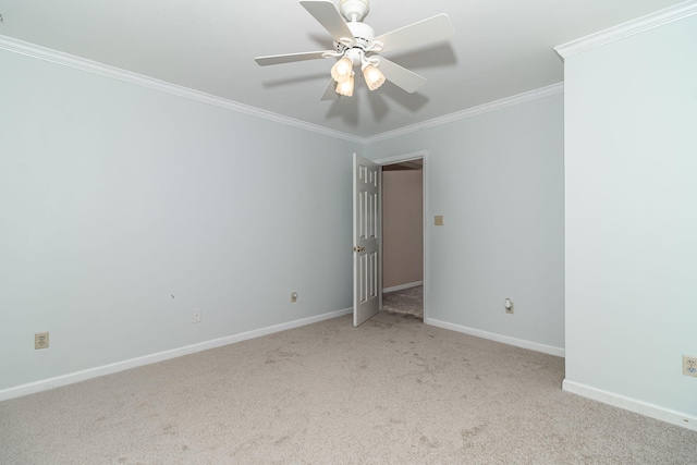 carpeted spare room featuring crown molding and ceiling fan