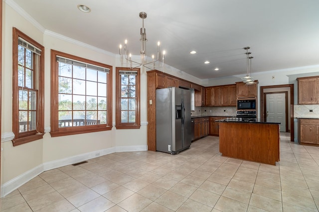 kitchen with decorative light fixtures, ornamental molding, a center island, light tile patterned floors, and black appliances