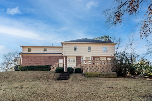 rear view of property featuring a wooden deck and a yard