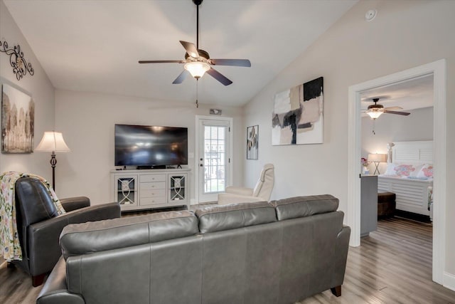 living room with ceiling fan, lofted ceiling, and light hardwood / wood-style floors