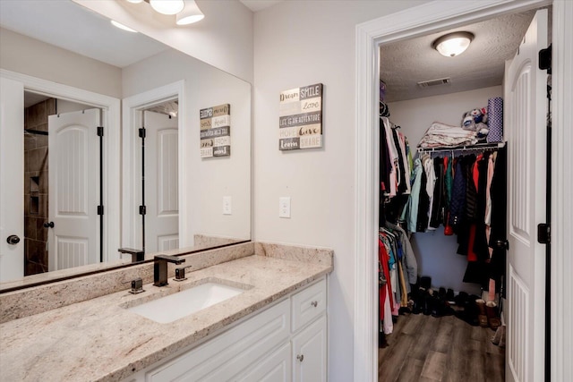 bathroom featuring vanity, hardwood / wood-style flooring, and a textured ceiling