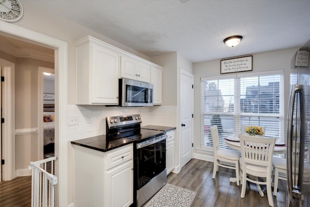 kitchen featuring white cabinetry, stainless steel appliances, and dark hardwood / wood-style floors