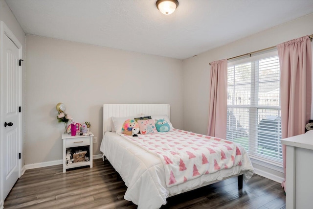 bedroom with multiple windows and dark hardwood / wood-style flooring