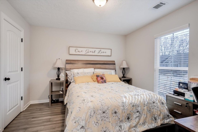 bedroom featuring hardwood / wood-style floors and a textured ceiling