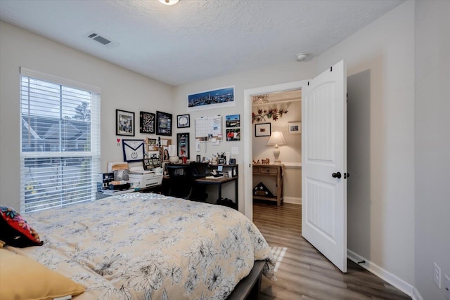 bedroom with wood-type flooring and a textured ceiling