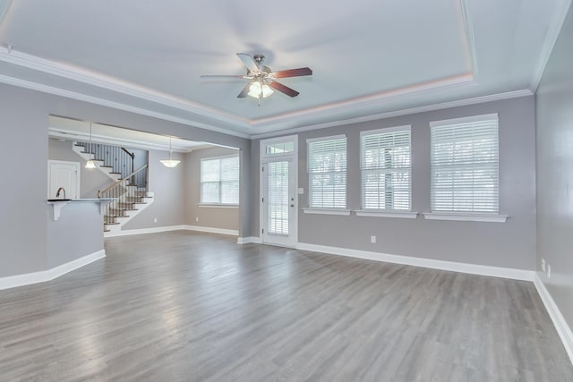 809 Richards Ct, Grovetown, GA 30813 - unfurnished living room featuring stairs, a ceiling fan, wood finished floors, crown molding, and a tray ceiling