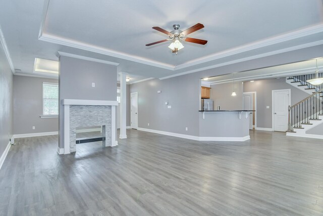 809 Richards Ct, Grovetown, GA 30813 - unfurnished living room featuring ceiling fan, stairway, a tray ceiling, wood finished floors, and ornamental molding