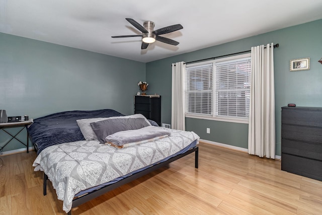 bedroom with light wood-style floors, baseboards, and ceiling fan