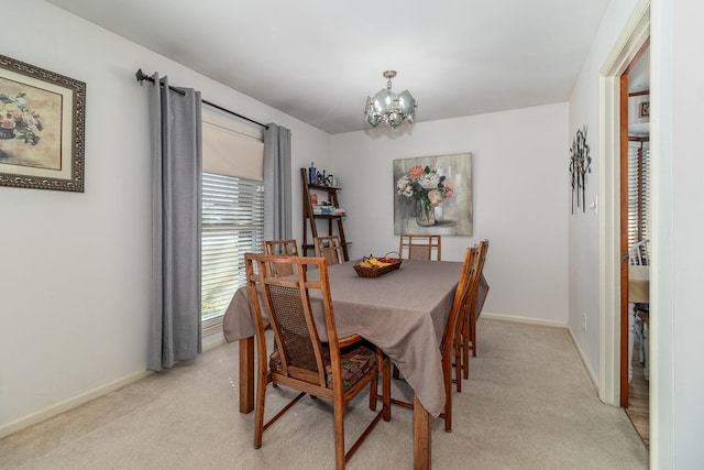 dining area with a chandelier, light colored carpet, and baseboards