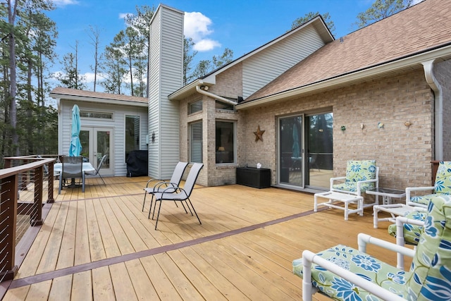 wooden terrace with a grill and french doors