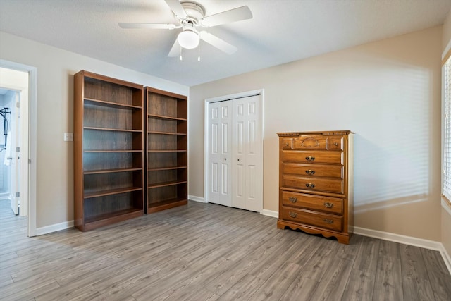 unfurnished bedroom with a closet, wood finished floors, and baseboards