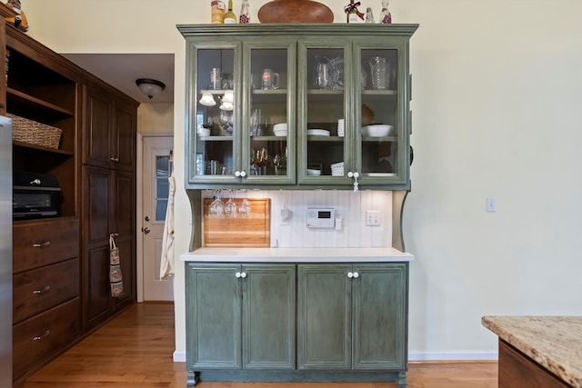 bar with light wood finished floors and baseboards