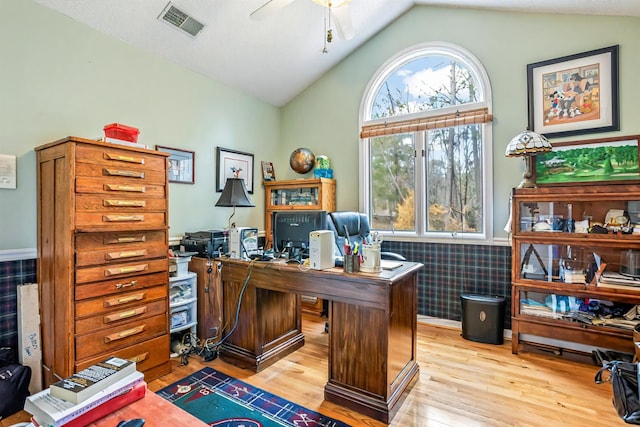 office featuring vaulted ceiling, a wainscoted wall, wood finished floors, and visible vents