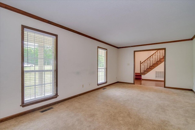 carpeted empty room featuring crown molding