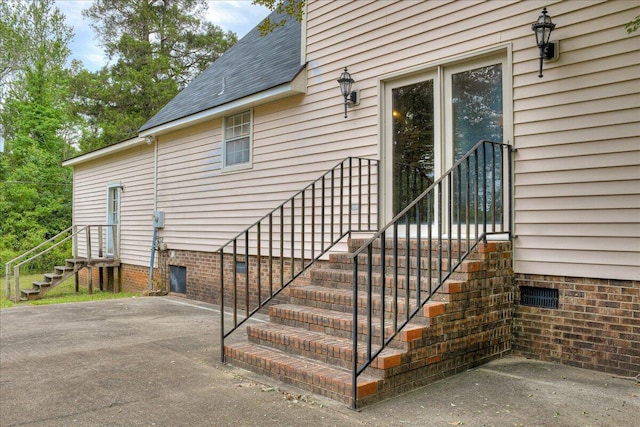 view of exterior entry with a patio