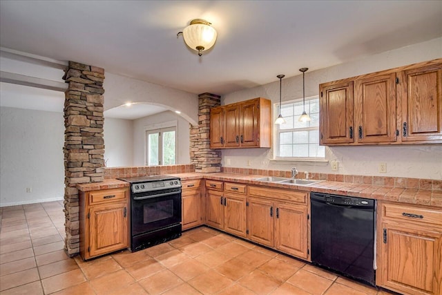 kitchen with sink, hanging light fixtures, decorative columns, light tile patterned floors, and black appliances