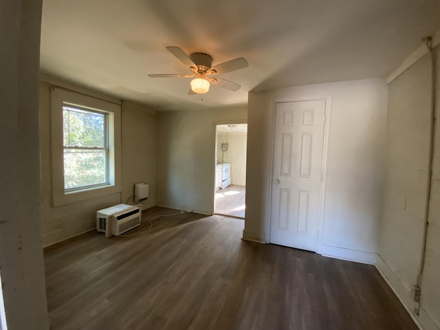 interior space with a wall mounted air conditioner, dark hardwood / wood-style floors, and ceiling fan