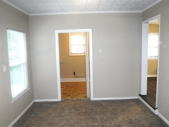 empty room featuring dark carpet and crown molding