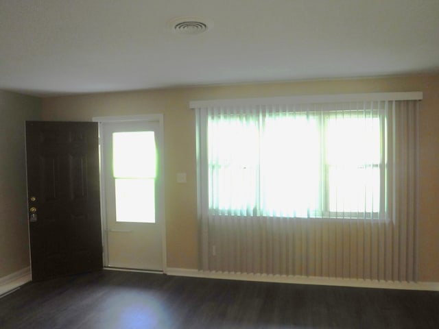 unfurnished room featuring dark hardwood / wood-style flooring and a healthy amount of sunlight