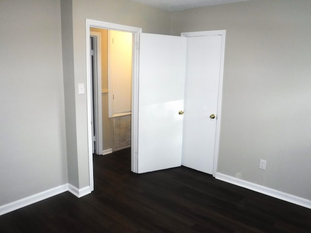 unfurnished bedroom with dark hardwood / wood-style flooring