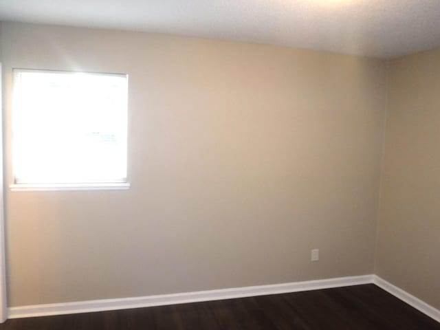 empty room featuring dark wood-type flooring