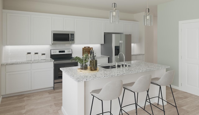 kitchen with tasteful backsplash, white cabinets, an island with sink, appliances with stainless steel finishes, and light wood-type flooring