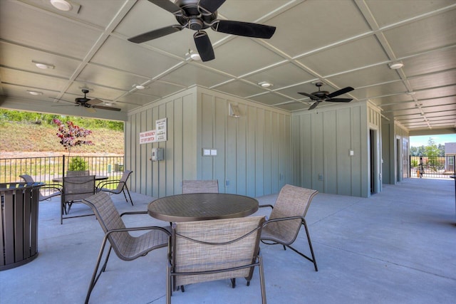 view of patio with fence, a ceiling fan, and outdoor dining space