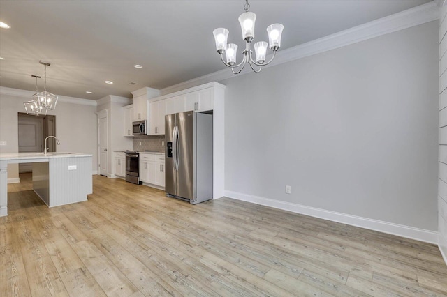 kitchen with a kitchen island with sink, hanging light fixtures, white cabinets, and stainless steel appliances