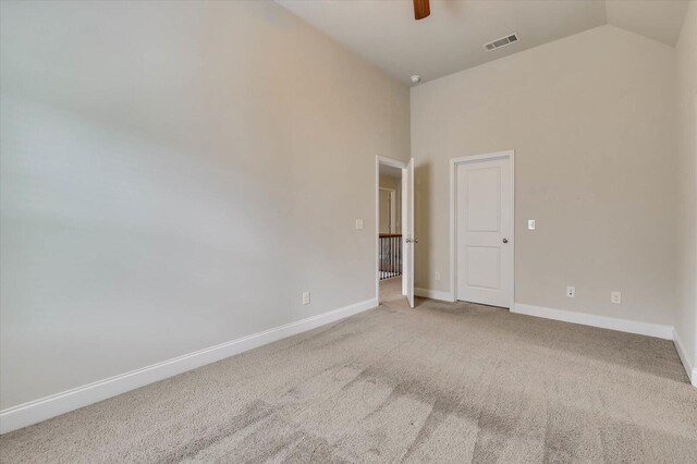 carpeted empty room featuring ceiling fan and lofted ceiling