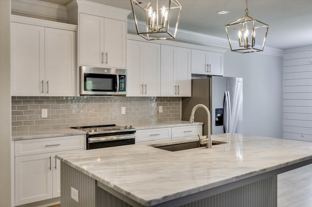 kitchen with white cabinets, decorative light fixtures, light stone countertops, and stainless steel appliances