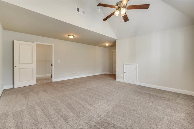 spare room featuring light carpet, ceiling fan, and high vaulted ceiling