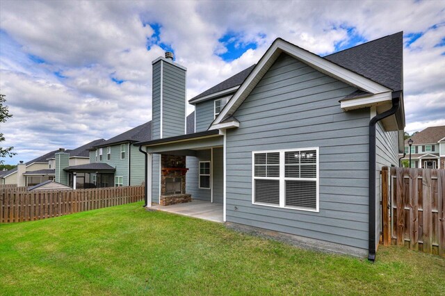 back of property featuring a lawn and a patio