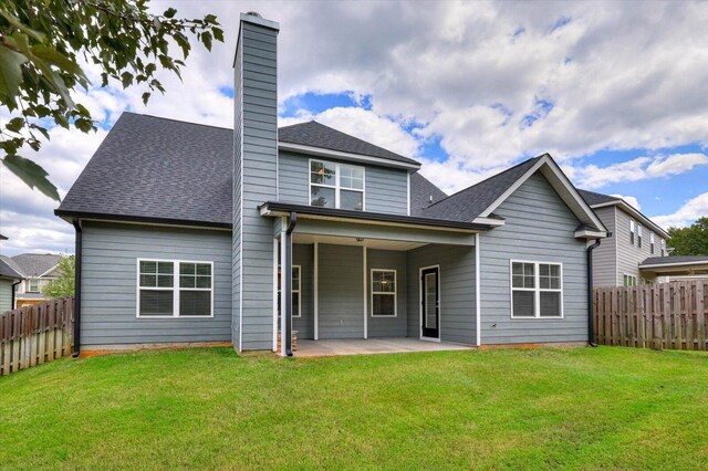 back of property with a lawn and a patio area