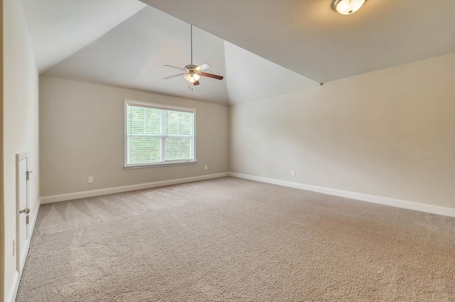 carpeted spare room with ceiling fan and lofted ceiling