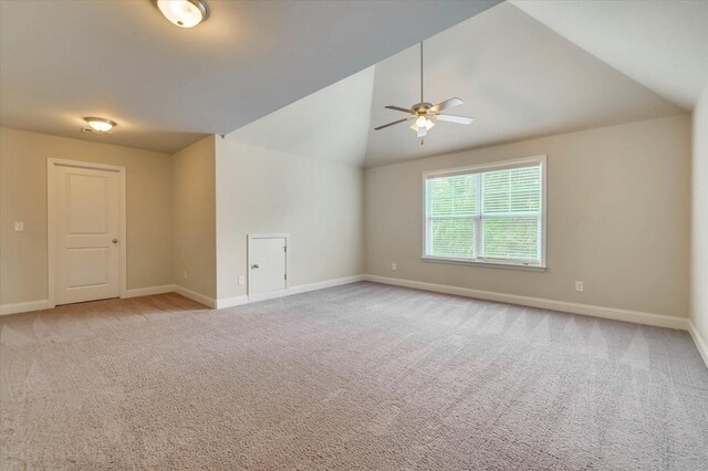 unfurnished room with ceiling fan, lofted ceiling, and light carpet