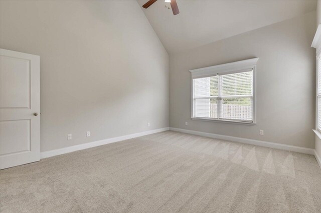 carpeted empty room featuring ceiling fan and high vaulted ceiling