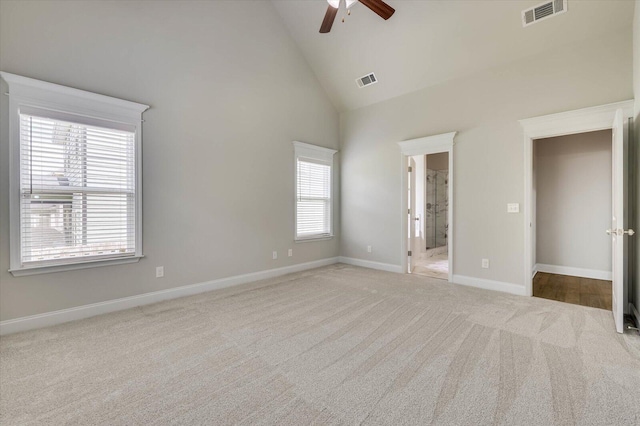 unfurnished bedroom featuring ceiling fan, high vaulted ceiling, and light carpet