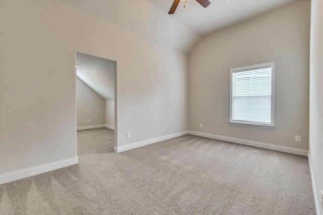 spare room featuring light colored carpet, ceiling fan, and lofted ceiling