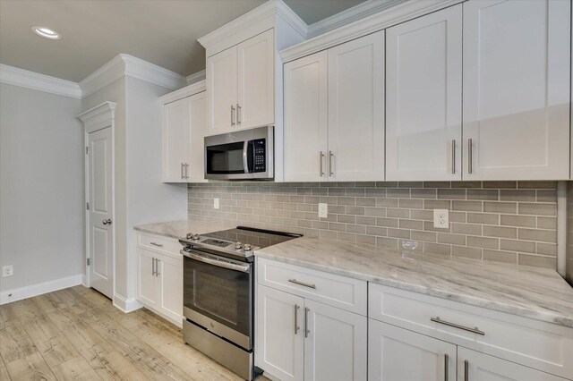 kitchen featuring decorative backsplash, appliances with stainless steel finishes, light stone counters, crown molding, and white cabinetry