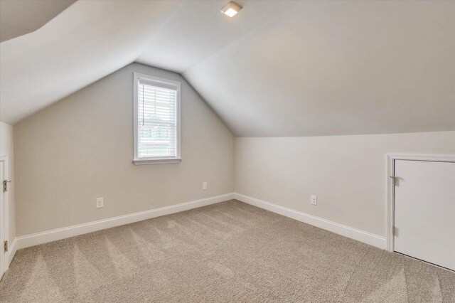 bonus room featuring carpet flooring and vaulted ceiling