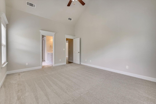 unfurnished bedroom with light carpet, ensuite bathroom, high vaulted ceiling, and ceiling fan